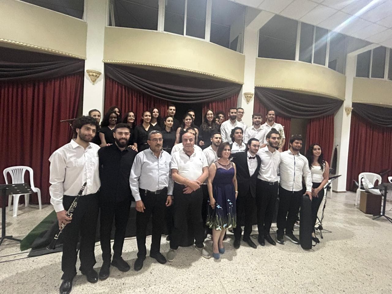 Members after a concert, in front of red curtains